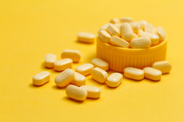vitamin-b-tablets-yellow-background_1387-415