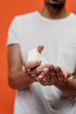 man washing his hands with soap bar