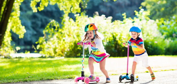 girl and boy kids happy on scooters
