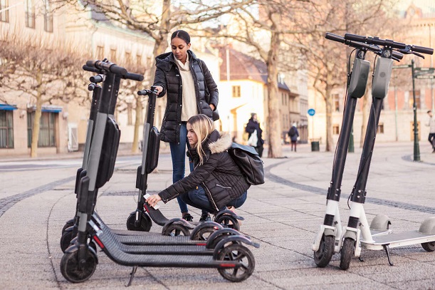 teenagers with scooters on street