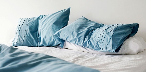 nice blue pillows on white sheets