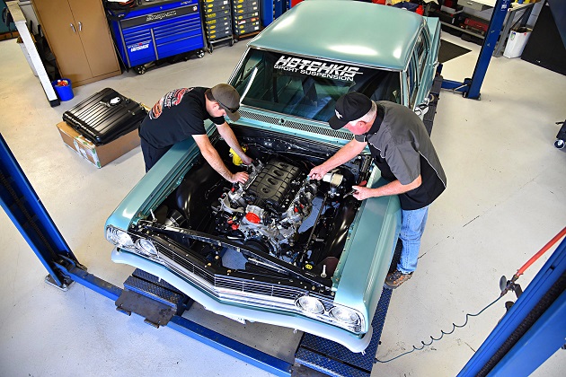 Two mechanics working on a car engine 