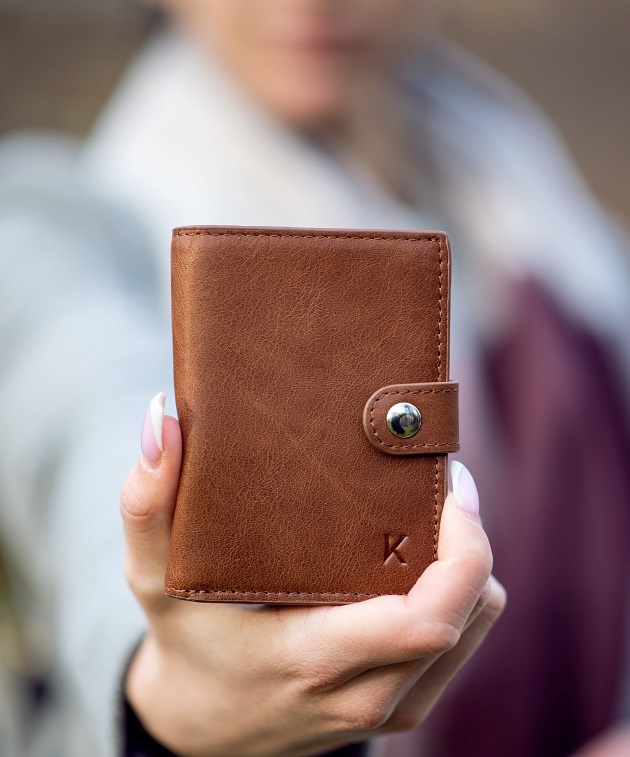 woman holding up leather wallet 
