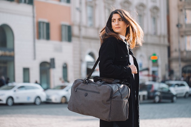 woman carrying a travel duffle bag 
