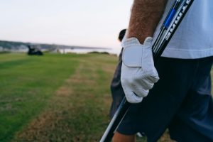 a person with high quality white golf gloves on a golf pitch